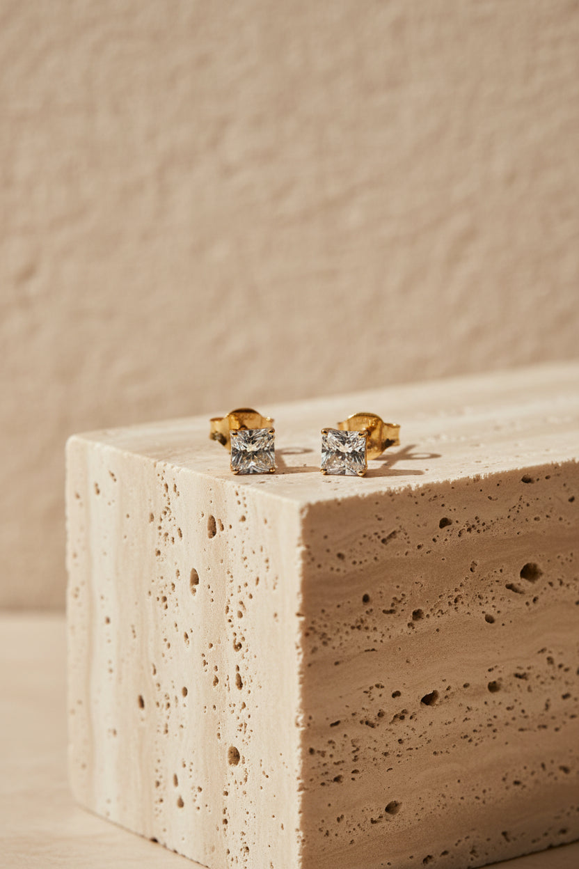 Close-up showing the secure gold butterfly backing and 4-prong setting of the square solitaire daily wear studs.