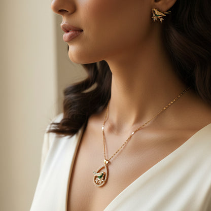 Hand holding gold jewelry with a visible brand tag in an indoor setting