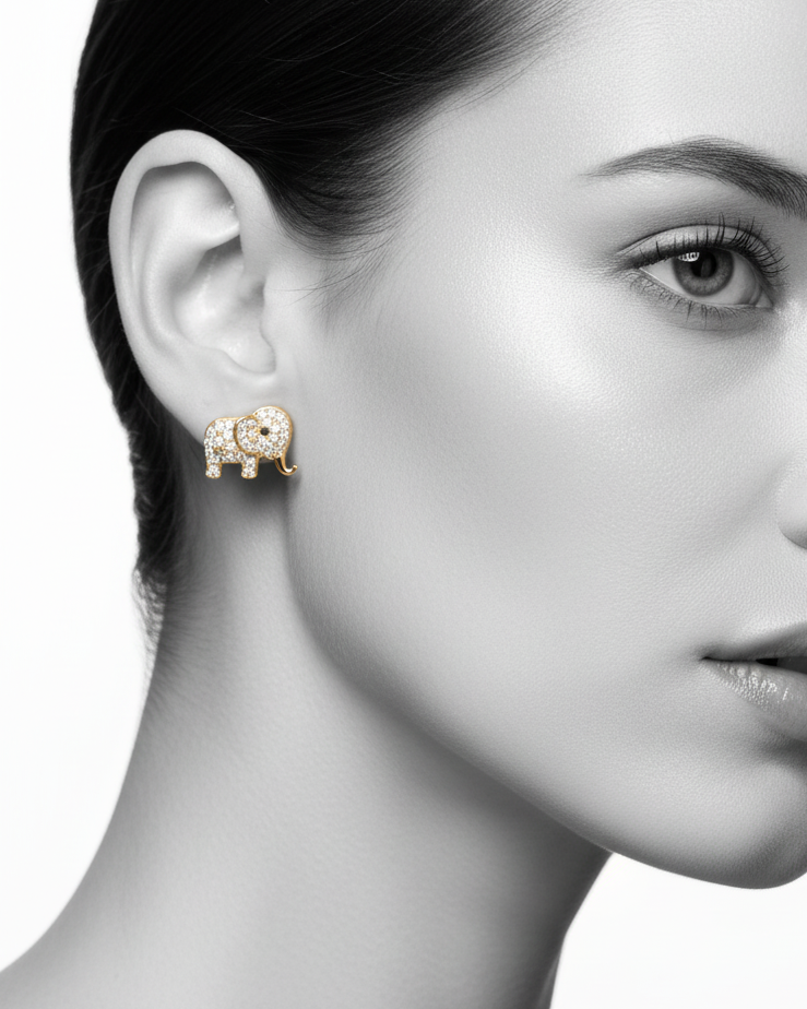 A pair of gold-plated elephant stud earrings fully encrusted with brilliant white cubic zirconia stones, displayed beautifully on a black fabric background.